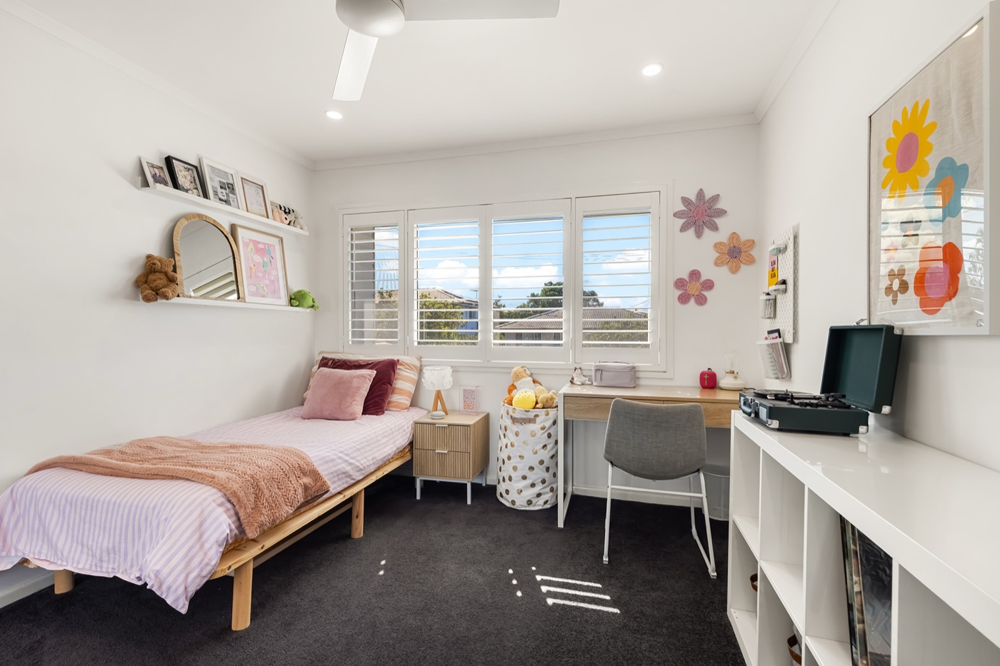 Third bedroom with a single bed, built-in desk and shelving, and plantation shutters to the garden