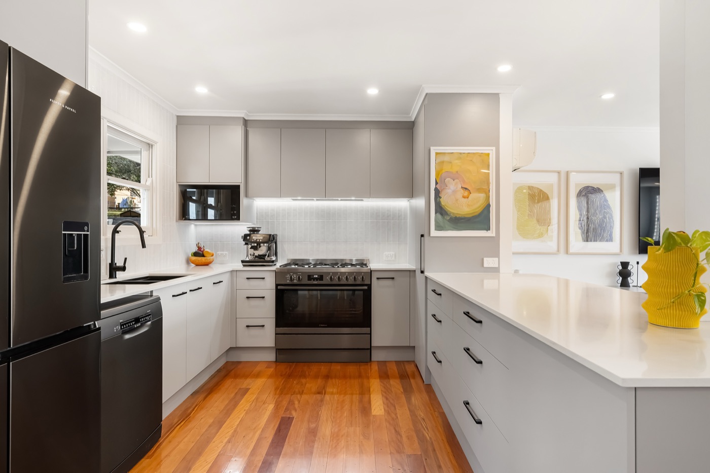 The 2025 kitchen with stone benchtops, custom cabinetry, five-burner gas cooktop and a 900mm oven