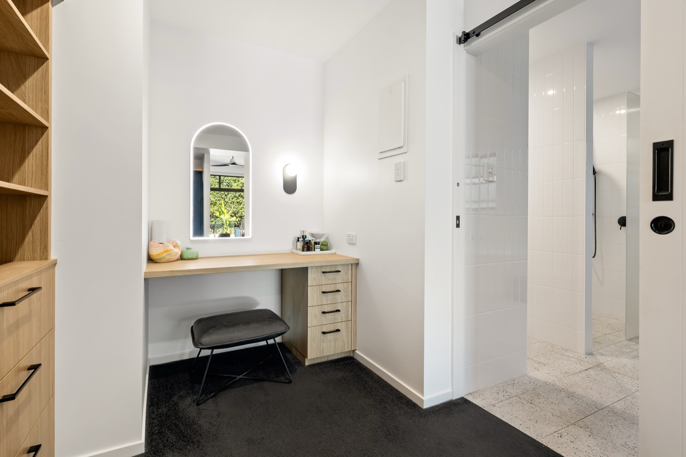 Walk-in robe with custom timber cabinetry, a dressing bench and mirror, leading through to the ensuite